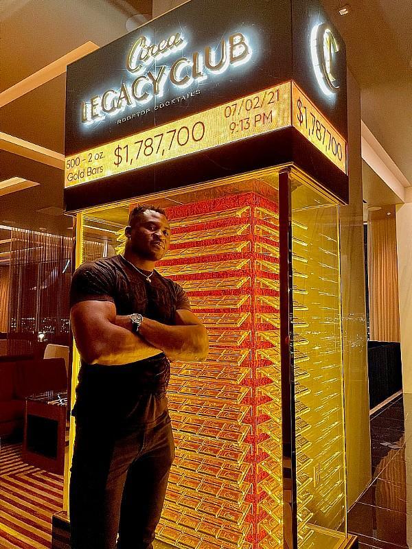 UFC Champ Francis Ngannou poses in front of the Gold Bar display at Legacy Club Rooftop Lounge at Circa Resort.