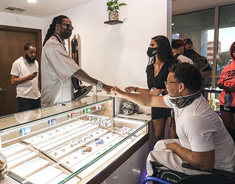 2 Chainz interacting with fans while working as a guest budtender at Jardín Premium Cannabis Dispensary