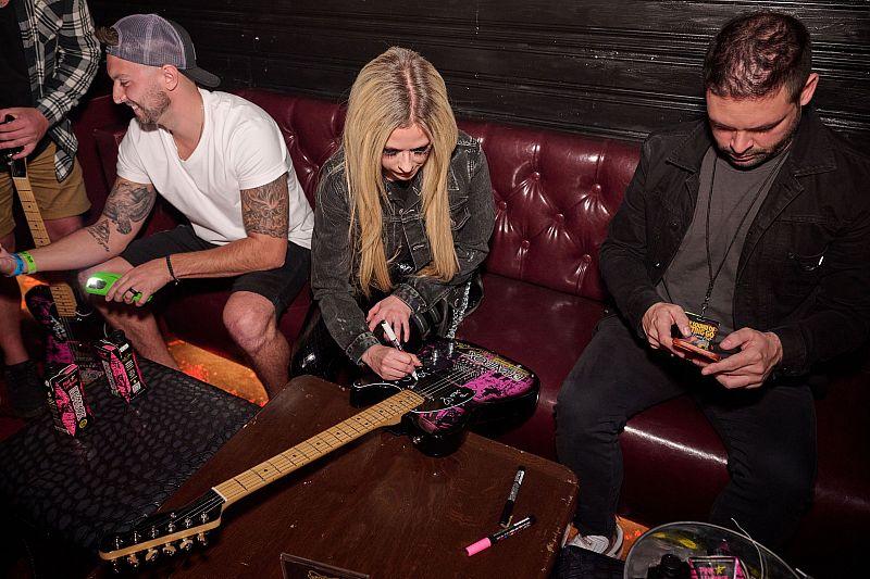 Avril Lavigne Autographs Guitars for fans at the Unite The United & Charity Bomb When We Were Young Festival Bowling Event to Benefit MusicCares, Presented by BeatBox Beverages in Las Vegas